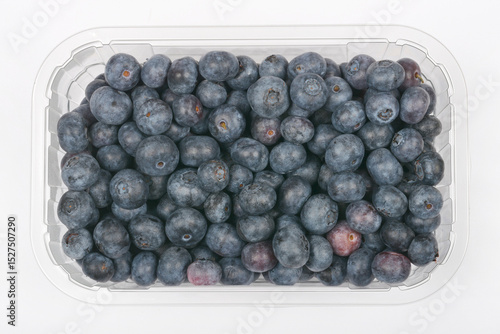 Konstfotografi A plastic container filled with fresh, ripe blueberries is viewed from above aga