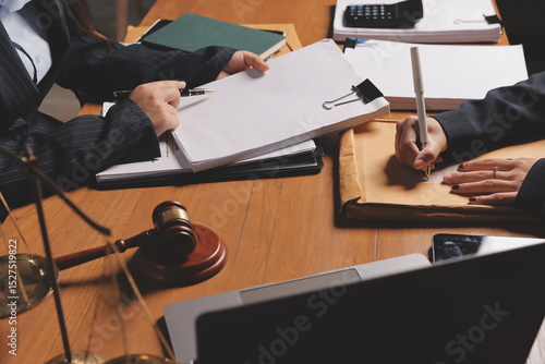 Attractive young lawyer in office Business woman and lawyers discussing contract papers with brass scale on wooden desk in office. Law, legal services, advice, Justice and real estate concept.