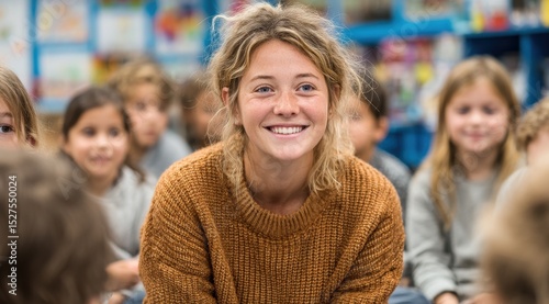 A woman with curly hair is smiling at a group of children