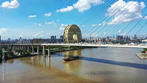 Guangzhou morning view of Nanpu bridge, river barge and the landmark Grand View building on a sunny day