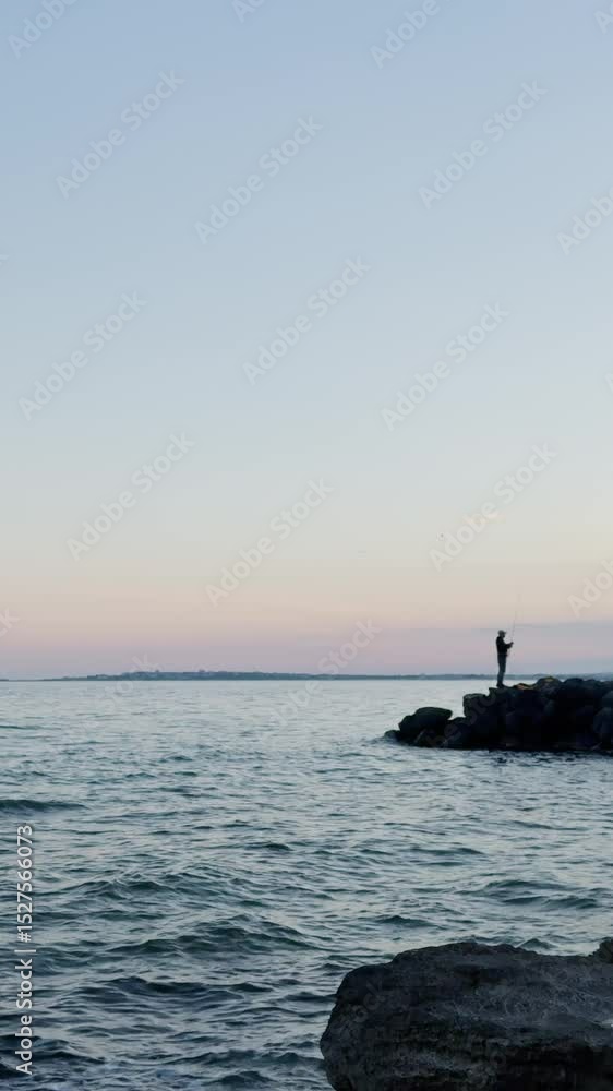 Coastline landscape, beautiful view of the sea, fisherman fishing at sunset, view of a stones and rocks, seascape vertical video background. Coastline landscape, beautiful view of the sea, fisherman fishing at sunset, view of a stones and rocks, seascape vertical video background.