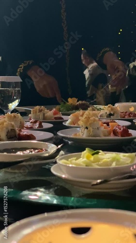 A male waiter is serving and distributing food to the guests at an elegant dinner banquet.