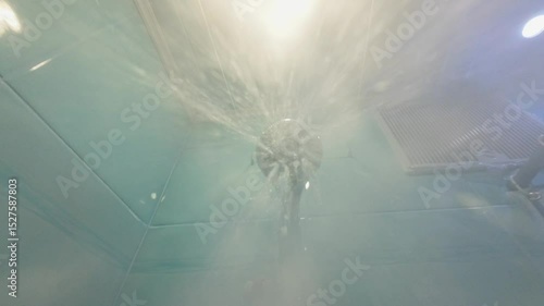The shower turns on, the water flows to the camera.	
