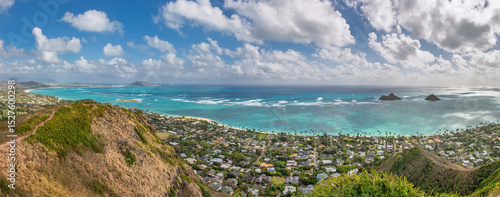 Panoramic view of famous Lanikai Beach and Kailua Bay on the island of Oahu, Hawaii, USA with Mokulua Islands or Twin Islands against blue sky with clouds