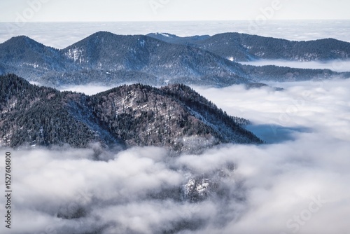 winter mountain landscape with snow, fog and cloud covered areas