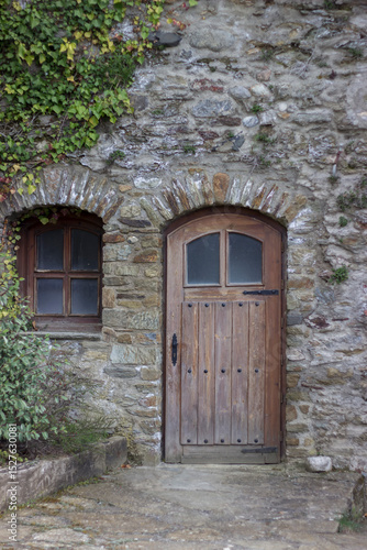 wooden door and small window in the wall of a stone castle