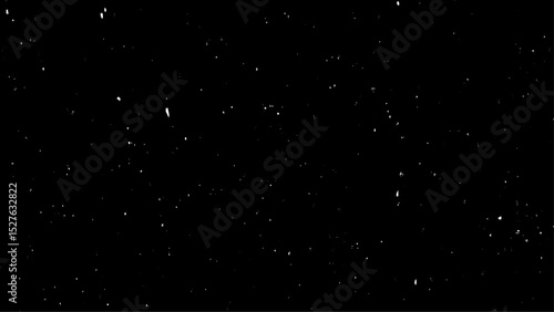Chaotic white bokeh on a black background with small falling snowflakes. Snow storm effect,