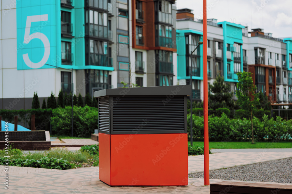 Naklejka premium contemporary urban kiosk with colorful backdrop features modern architecture and a vibrant geometric design, set against residential buildings, lush greenery, bright colors, and a large number 5