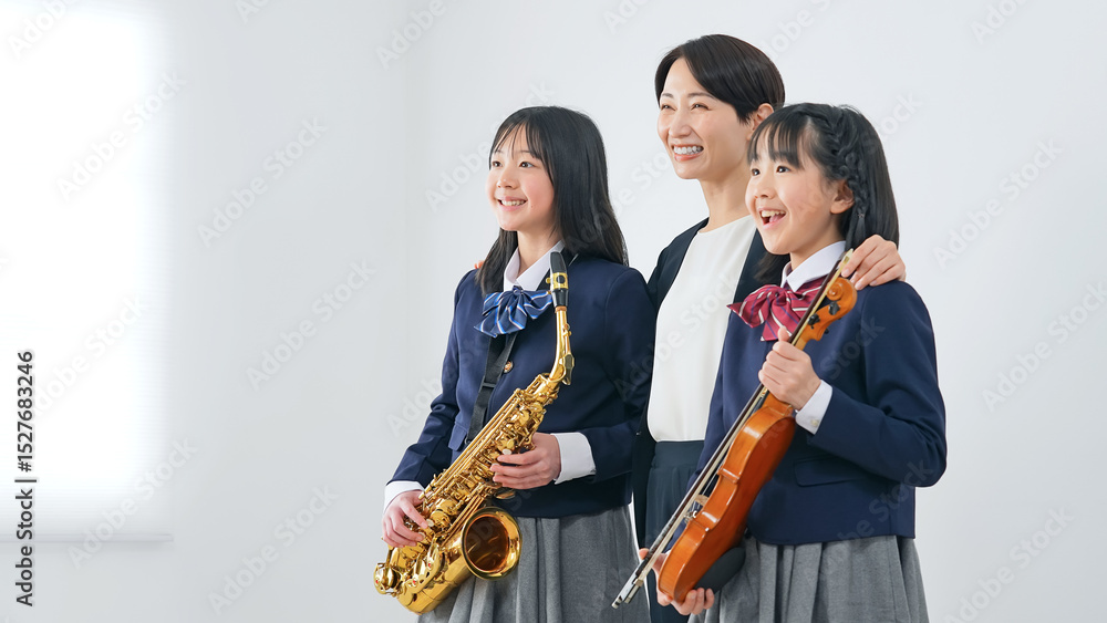 Fototapeta premium サックスとバイオリンを持った女子学生グループと女性教師
