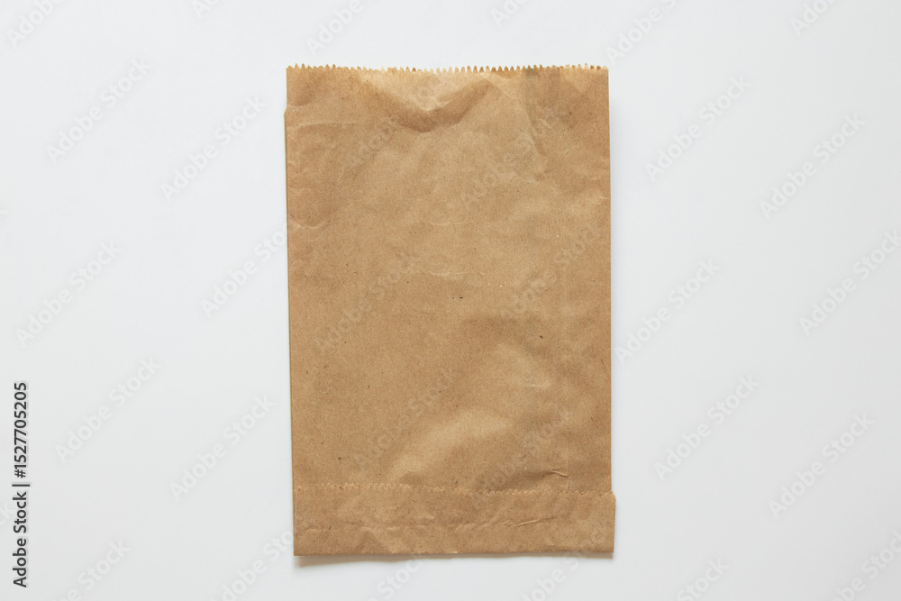 Fototapeta premium Brown paper bag on white background as mockup, kraft paper packaging, top view