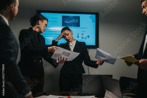 Photos Group of professionals analyzing complicated data in a modern office setting to strategize performance improvements and collaboration