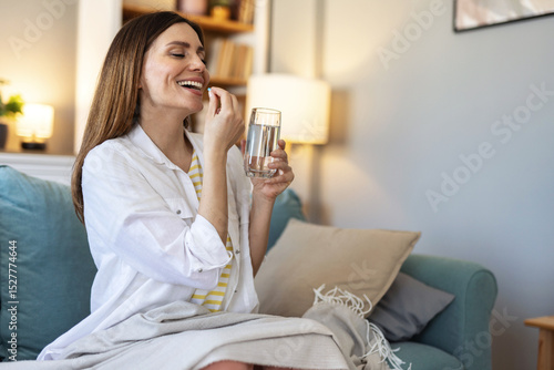 Fotografie Woman takes medicines with glass of water