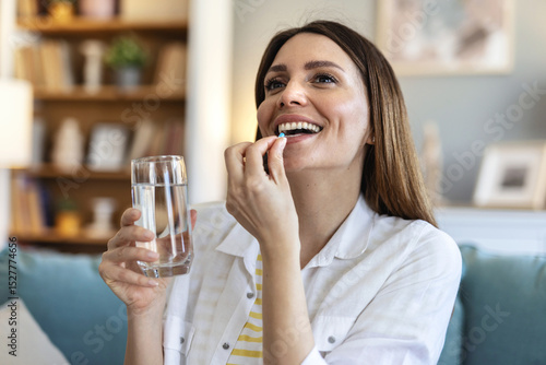 Woman takes medicines with glass of water. Daily norm of vitamins, effective drugs, modern pharmacy for body and mental health concept.