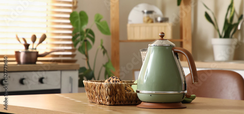 Tableau sur toile Electric kettle with basket of cookies on table in kitchen