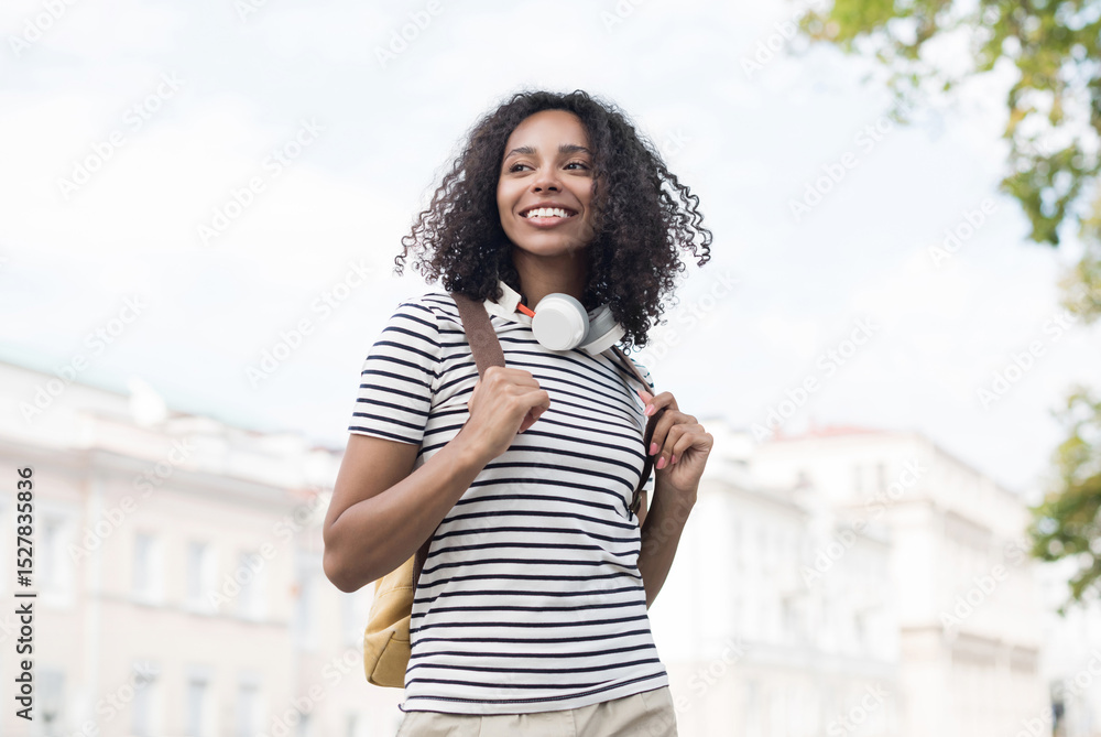 Fototapeta premium Young beautiful woman summer portrait, Happy african american student girl smiling in a city, People enjoy life, student lifestyle, city life, travel concept