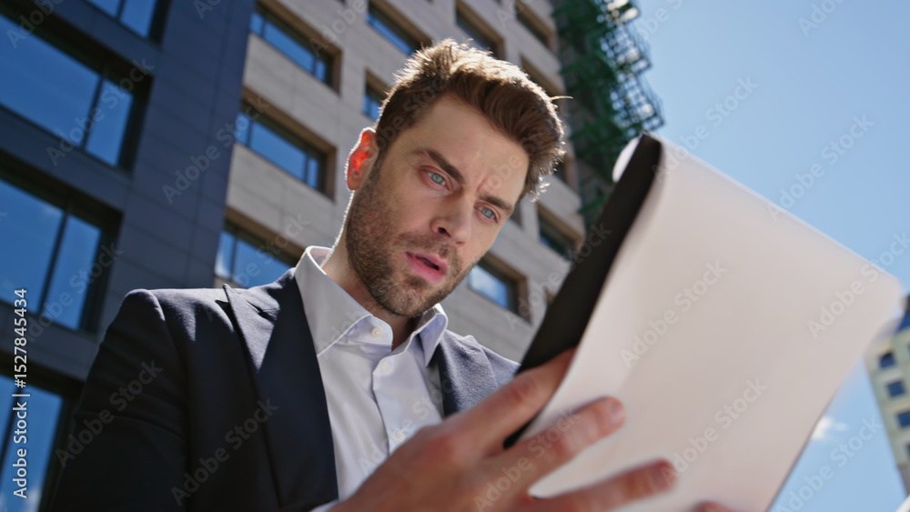 Fototapeta premium Frustrated manager analysing documents standing business street closeup. 