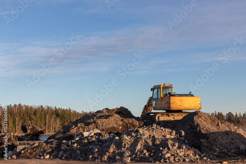 Wallpaper Mural Yellow excavator groundworks on sunset, digger on construction site on blue sky. Heavy construction equipment on excavation on construction site, open-pit mining Torontodigital.ca