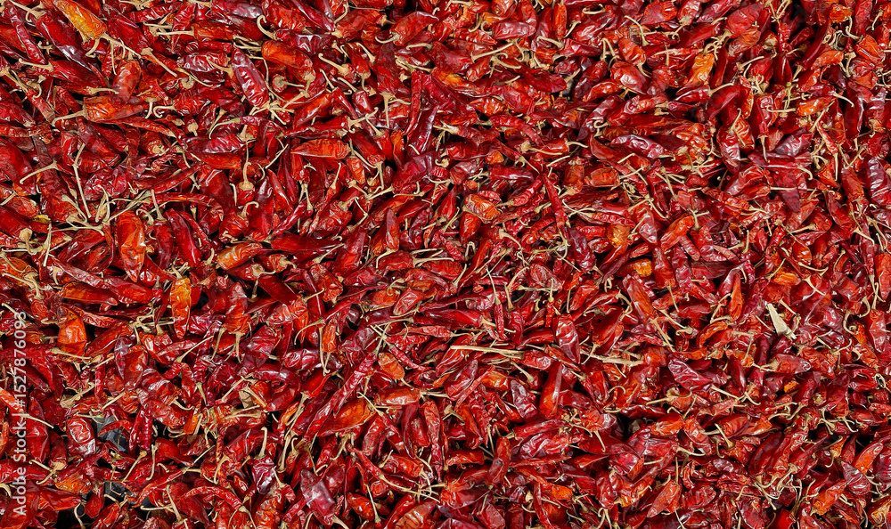 Naklejka premium Top view of a large pile of dried red chili peppers, spicy food background texture with vibrant red hues.