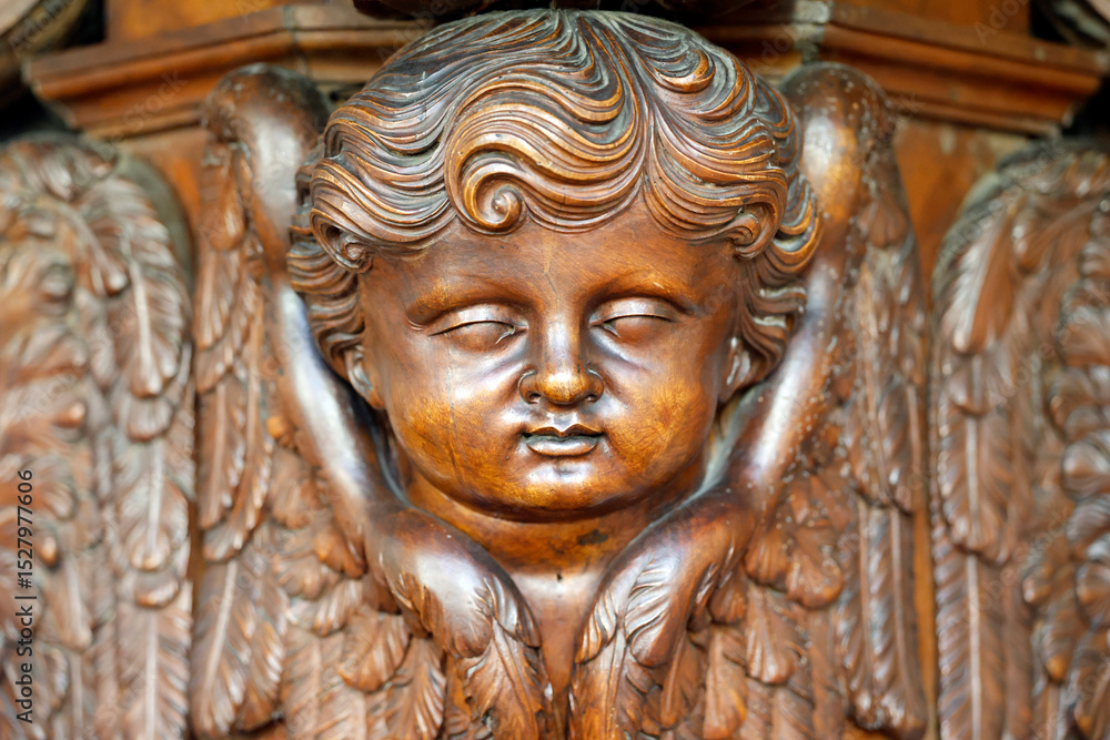 Fototapeta premium Collegiate Church of Saint-Jacques le Majeur. Wooden sculpture of a cherub. Sallanchess. France.