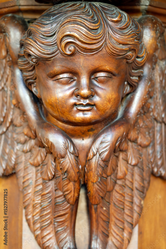 Fototapeta premium Collegiate Church of Saint-Jacques le Majeur. Wooden sculpture of a cherub. Sallanchess. France.