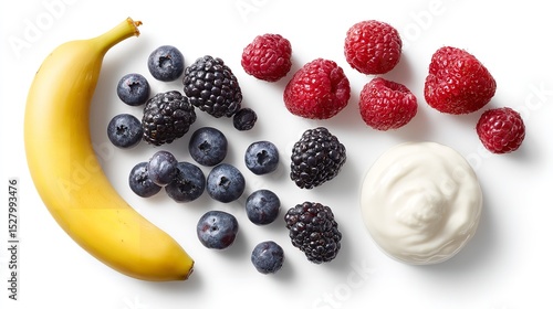 A top down view of a banana with berries and yogurt on a white surface ready to be eaten