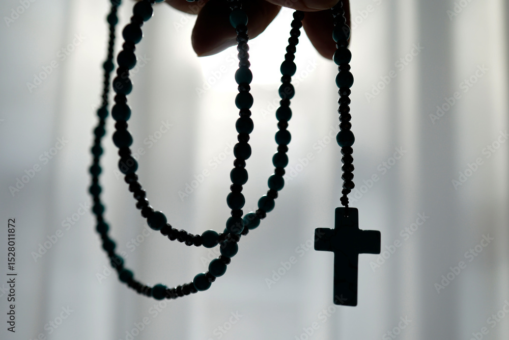 Silhouette of a man's hand praying the rosary. Silhouette of a man's hand praying the rosary.