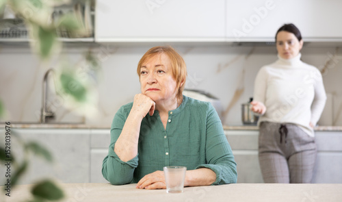 Photos Daughter stands behind mother and argues about position in life