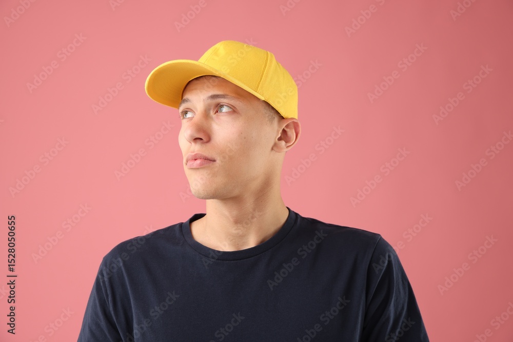 Young man in stylish baseball hat on pink background Young man in stylish baseball hat on pink background
