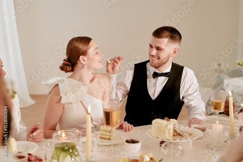 Photography Caucasian young adult man feeding cake to Caucasian young adult woman during wed