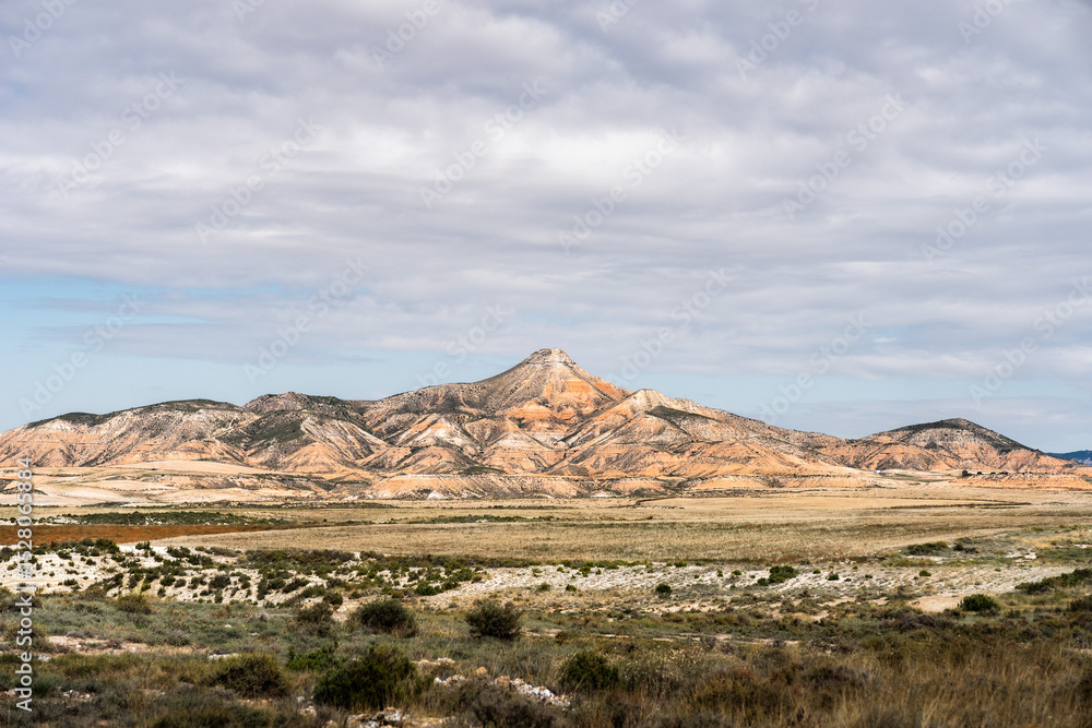 Fototapeta premium Bardenas reales natural park showcasing rock formations under cloudy sky in navarra, spain