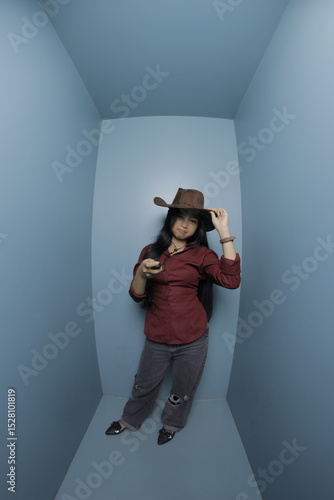 Woman in a cowboy hat lying in a blue room