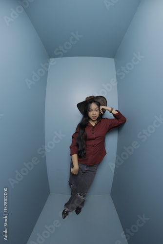 Woman in a cowboy hat lying in a blue room