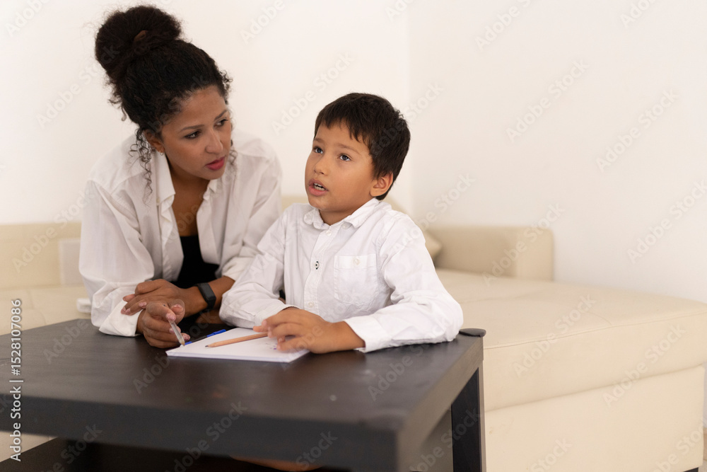 Teacher helping young pupil with homework in classroom Teacher helping young pupil with homework in classroom