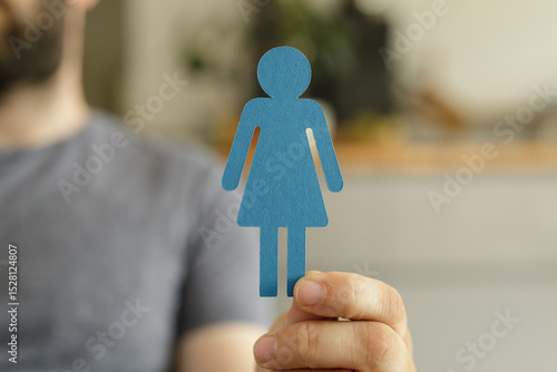 A man holds a blue paper cu...