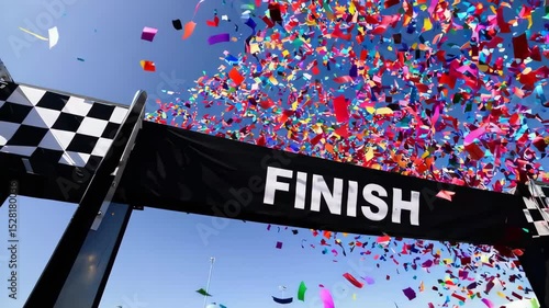 Explosion of vibrant confetti in mid-air at race finish line under clear blue sky, symbolizing celebration, sports victory, event finale and joyful moment