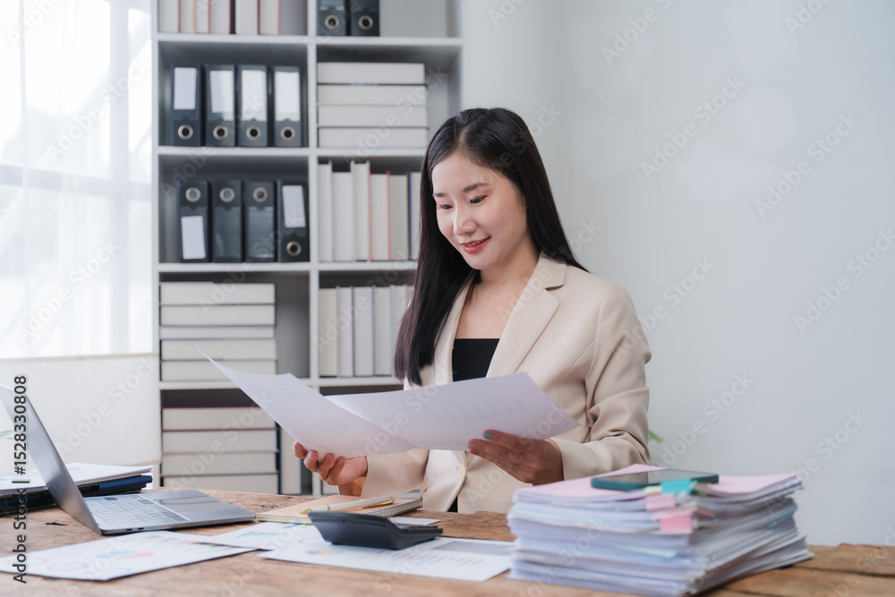 Asian Businesswoman Reviewing Documents in Office Asian Businesswoman Reviewing Documents in Office