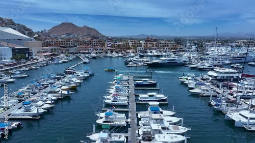 Aerial Cabo San Lucas Mexico marina to city 1. Resort city southern tip of Baja California peninsula. Beach and malecon markets. Eco tourism. Destination vacation and business. Commercial seaport.