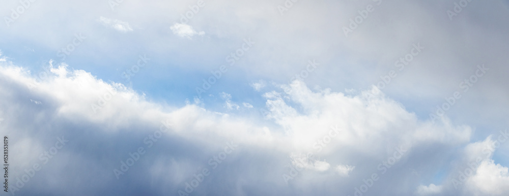 Obraz premium A low-angle view of a cloudy sky with sunlight breaking through the upper clouds