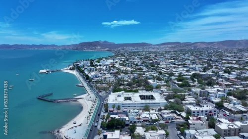 Aerial La Paz Mexico city along ocean bay 1. Capital Mexican state of Baja California Sur, peninsula. Ferry, fishing, cargo and cruise ships. Beach Malecon markets. Eco tourism economy.