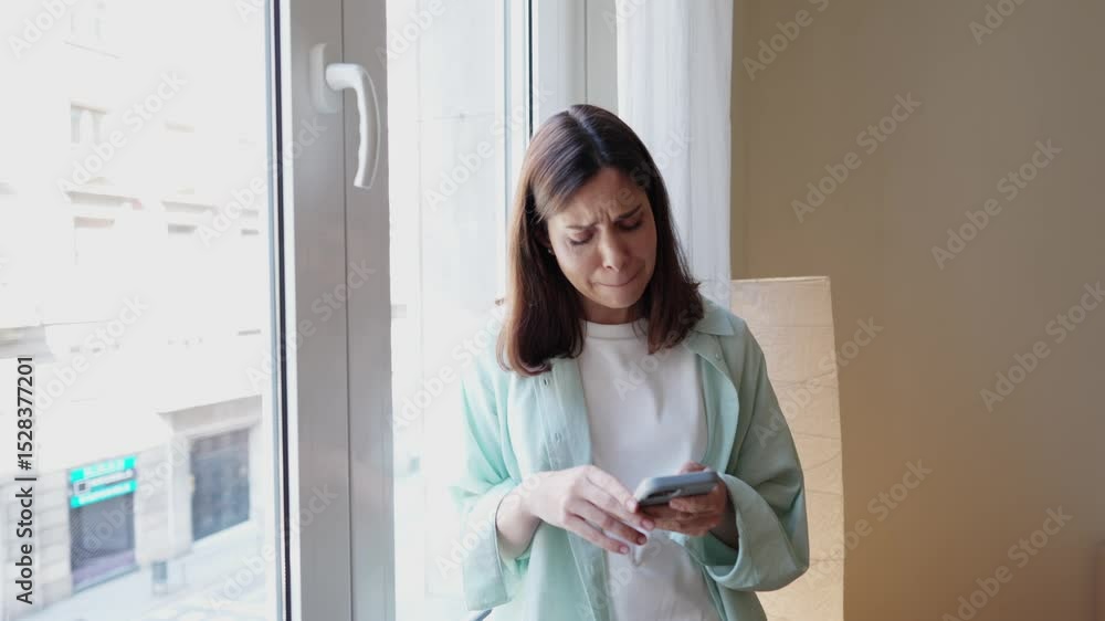 Woman feeling sad while reading bad news on smartphone Woman feeling sad while reading bad news on smartphone