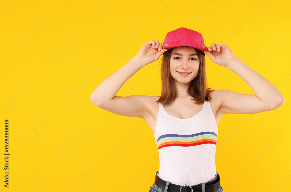 Young woman wearing stylish pink baseball hat on yellow background, space for text Young woman wearing stylish pink baseball hat on yellow background, space for text