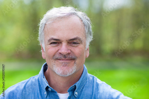 Close up outdoor portrait of mature man looking at camera.