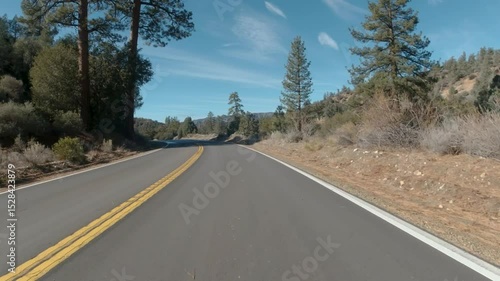 Driving through a mountainous national forest with blue skies