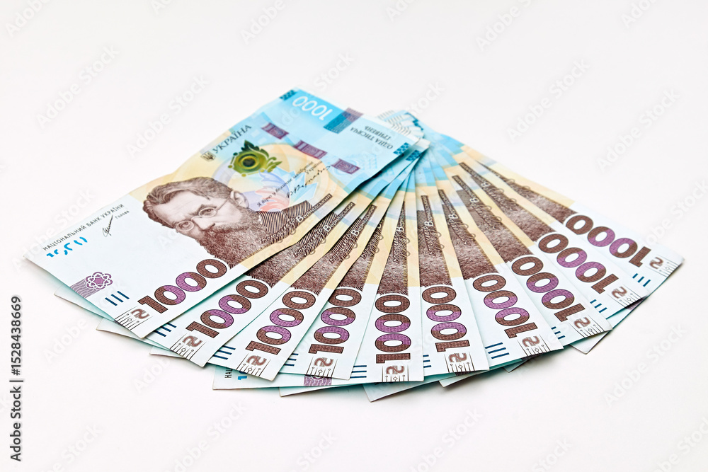 Ukrainian 1000-hryvnia banknotes arranged in a fan shape on a white background. Ukrainian 1000-hryvnia banknotes arranged in a fan shape on a white background.