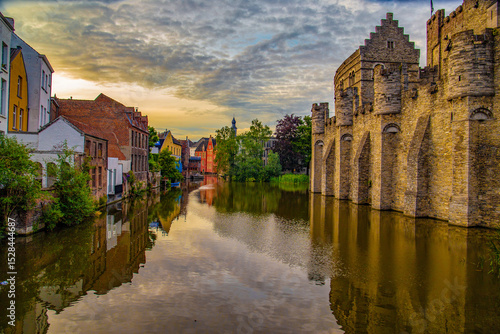 European canal in Belgium Ghent with city centre castle and water reflections.  
