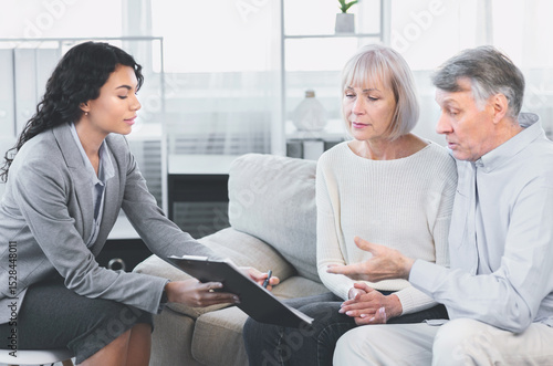 Wallpaper Mural Last Will And Testament. Mature man sitting on couch embracing wife, asking about document, signing papers with consultant Torontodigital.ca