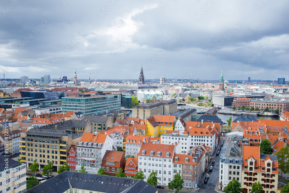 Obraz premium Panoramic view of the center of Copenhagen city in Denmark from the top of the Church of our Savior. Dramatic cloudy sky before raining under the city