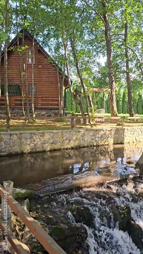 Peaceful nature retreat with a wooden cabin, flowing stream, waterfalls, and a tree swing. Ideal for vacation, relaxation, ecotourism, and outdoor lifestyle visuals. Peaceful nature retreat with a wooden cabin, flowing stream, waterfalls, and a tree swing. Ideal for vacation, relaxation, ecotourism, and outdoor lifestyle visuals.