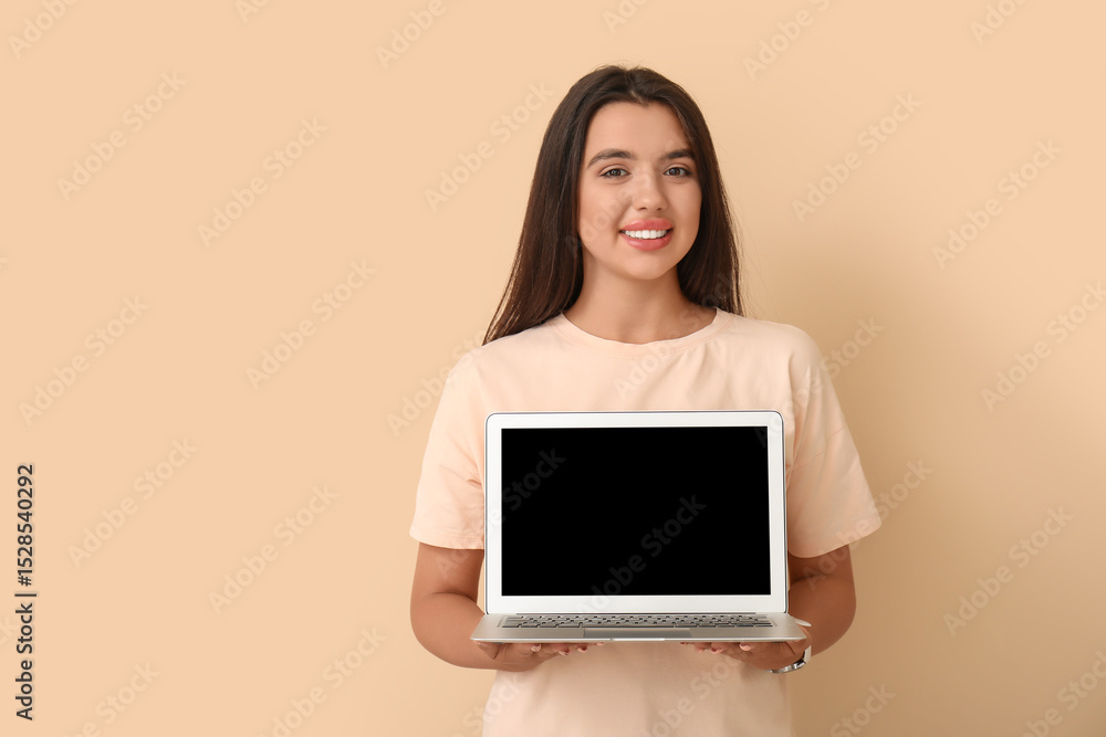 Naklejka premium Happy young female programmer with laptop on beige background