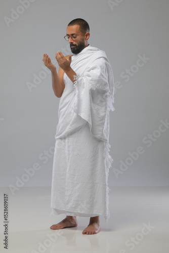 
Muslim man wearing Ihram clothing during Hajj or Umrah, captured in various poses—walking, praying, drinking water, and reading. Studio concept illustrating Islamic pilgrimage rituals.